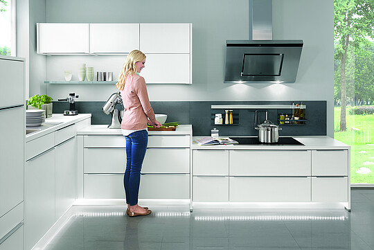 Frau steht in einer Küche mit verschiedenen Arbeitshöhen 
